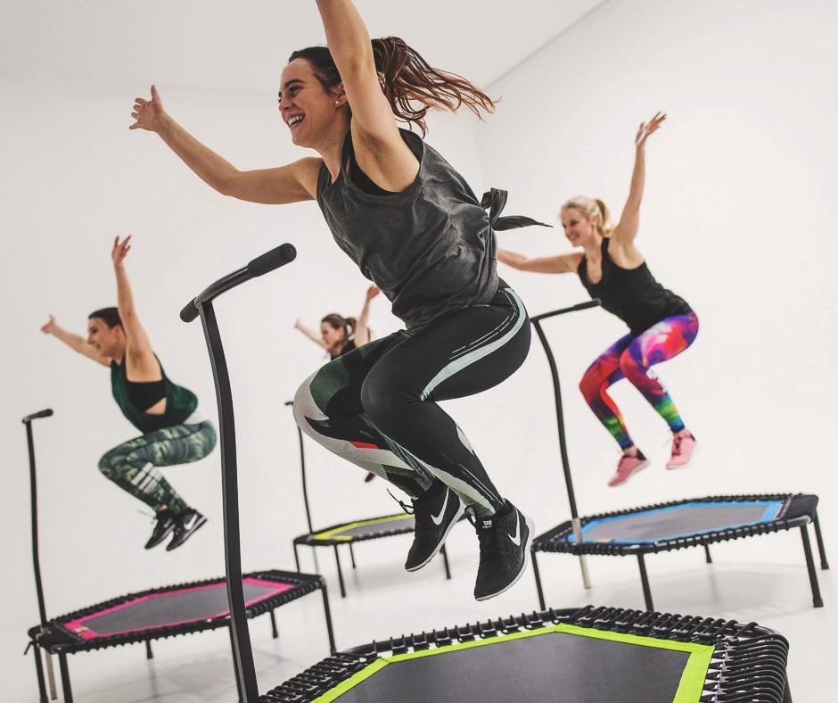 Frau beim intensivem Trampolin-Workout Jumping.