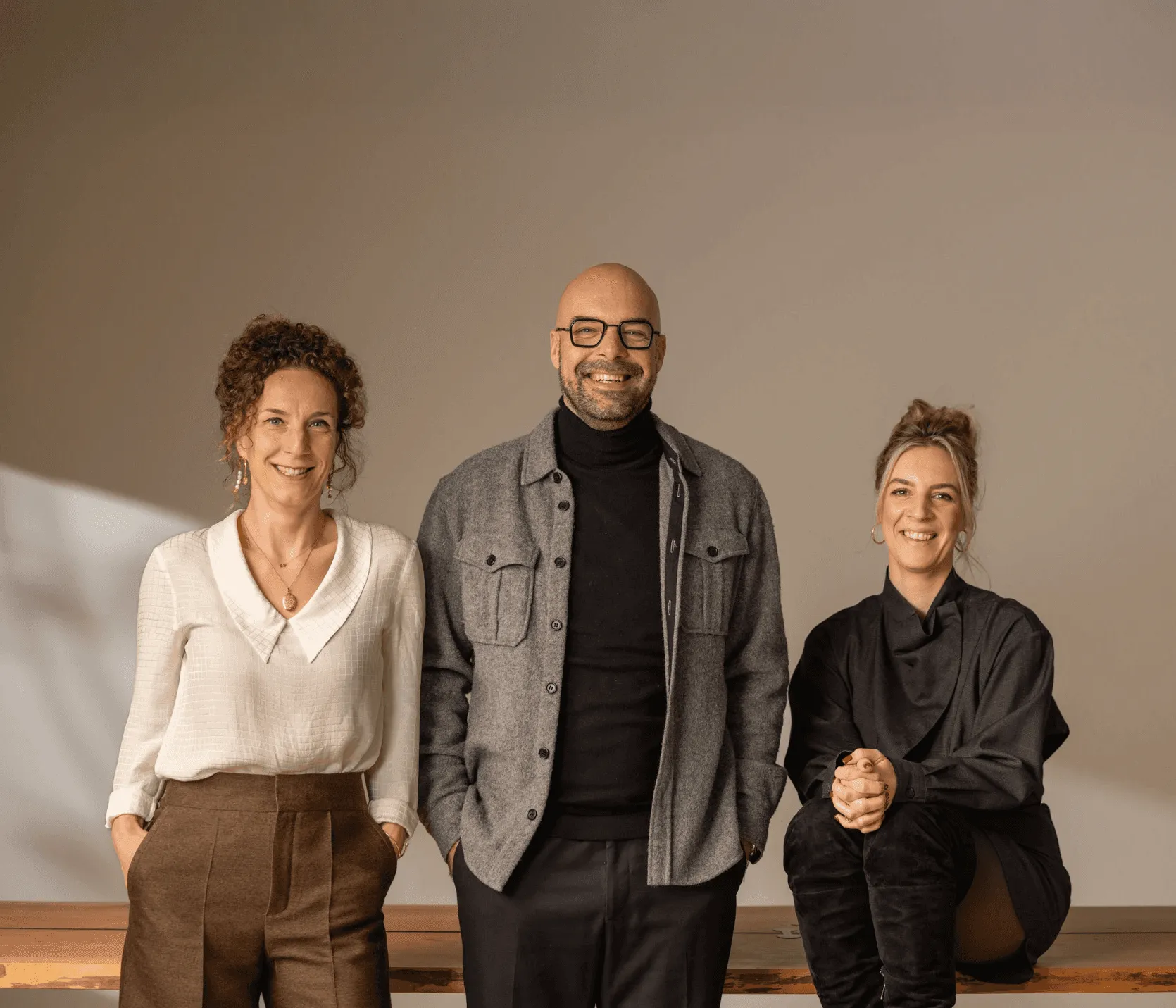 Smiling group portrait of two women and one man.