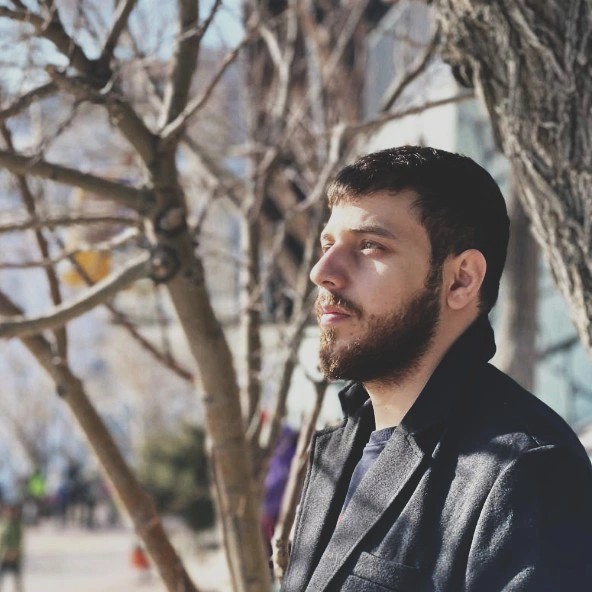 Black and white portrait of a smiling person with curly hair