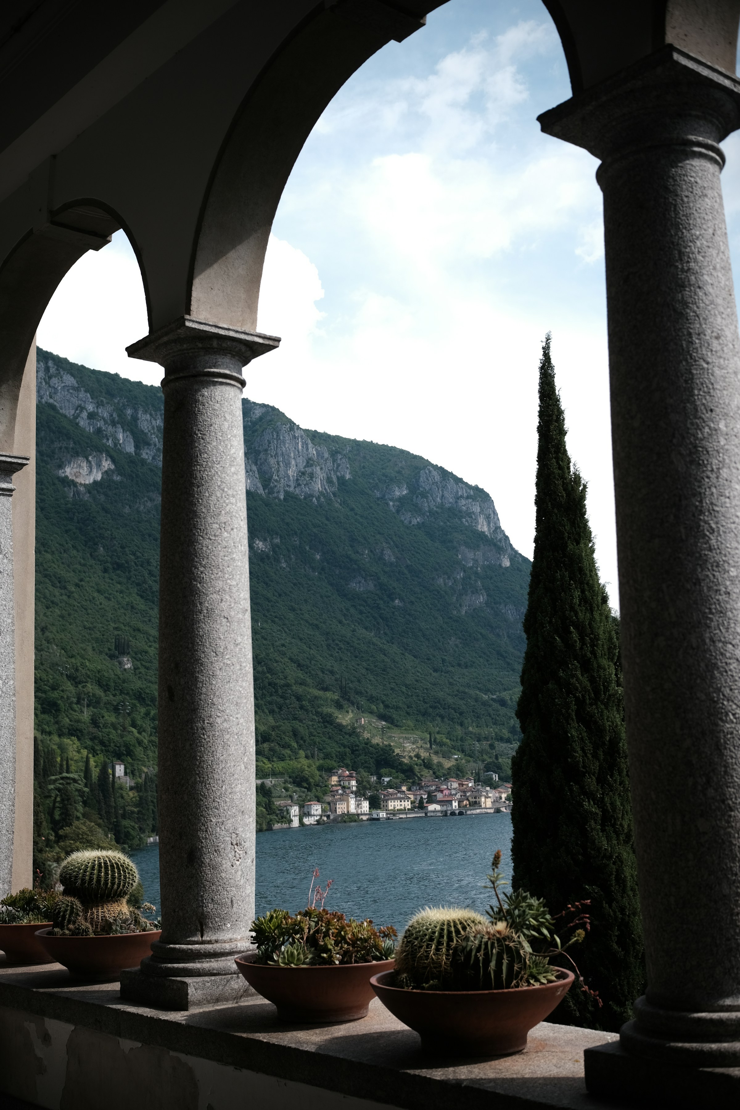 Arched stone loggia opening onto the lake and the mountains beyond