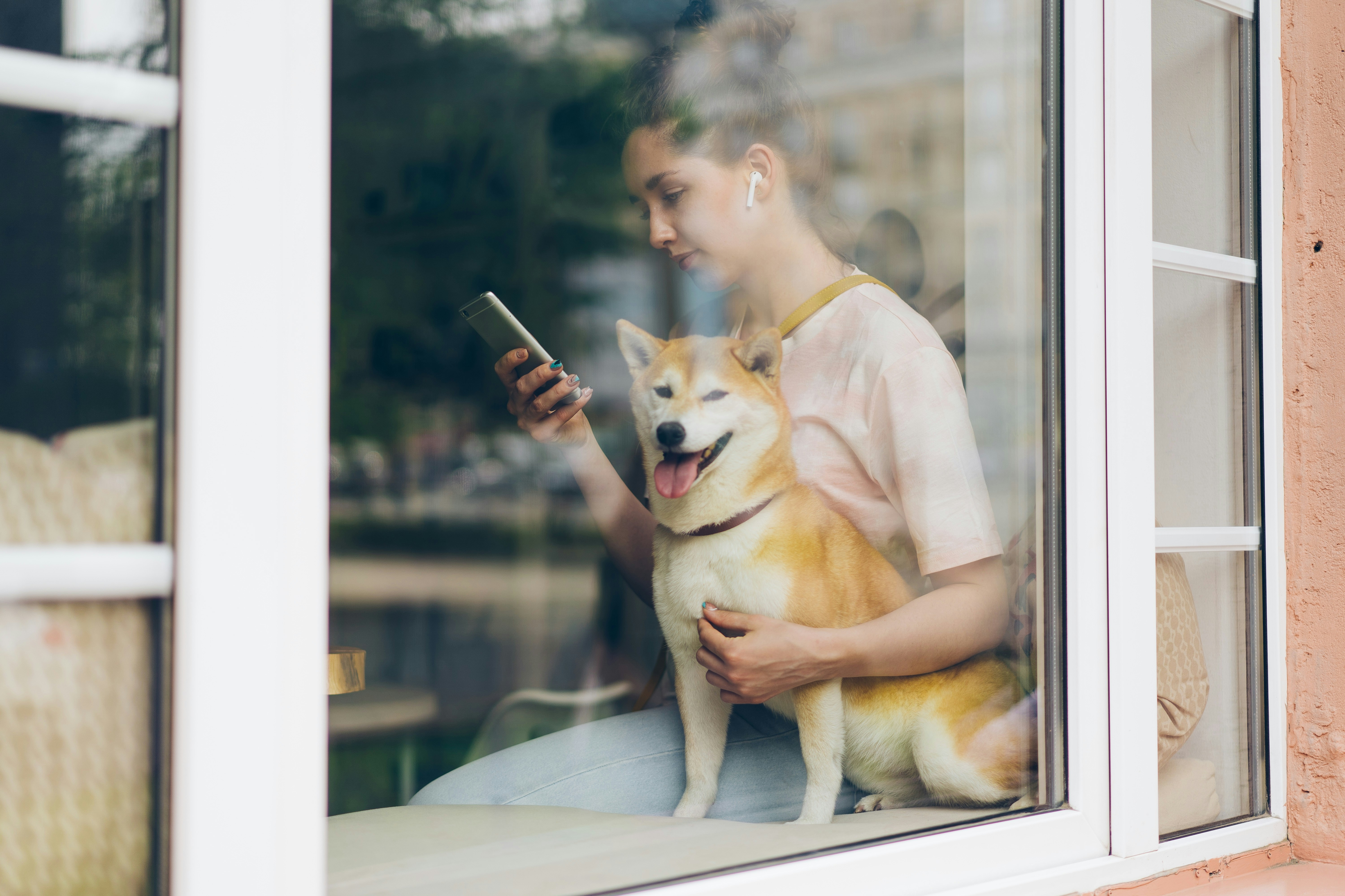 Girl wearing Headphones sitting by window- Free Reading Apps You Should Know