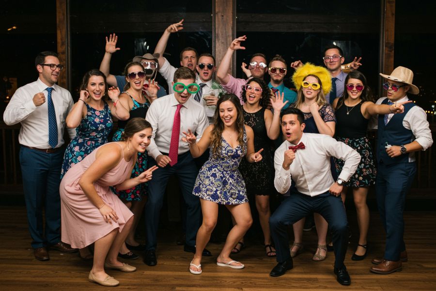 Group of sevent people in a photo booth wearing funny hats.