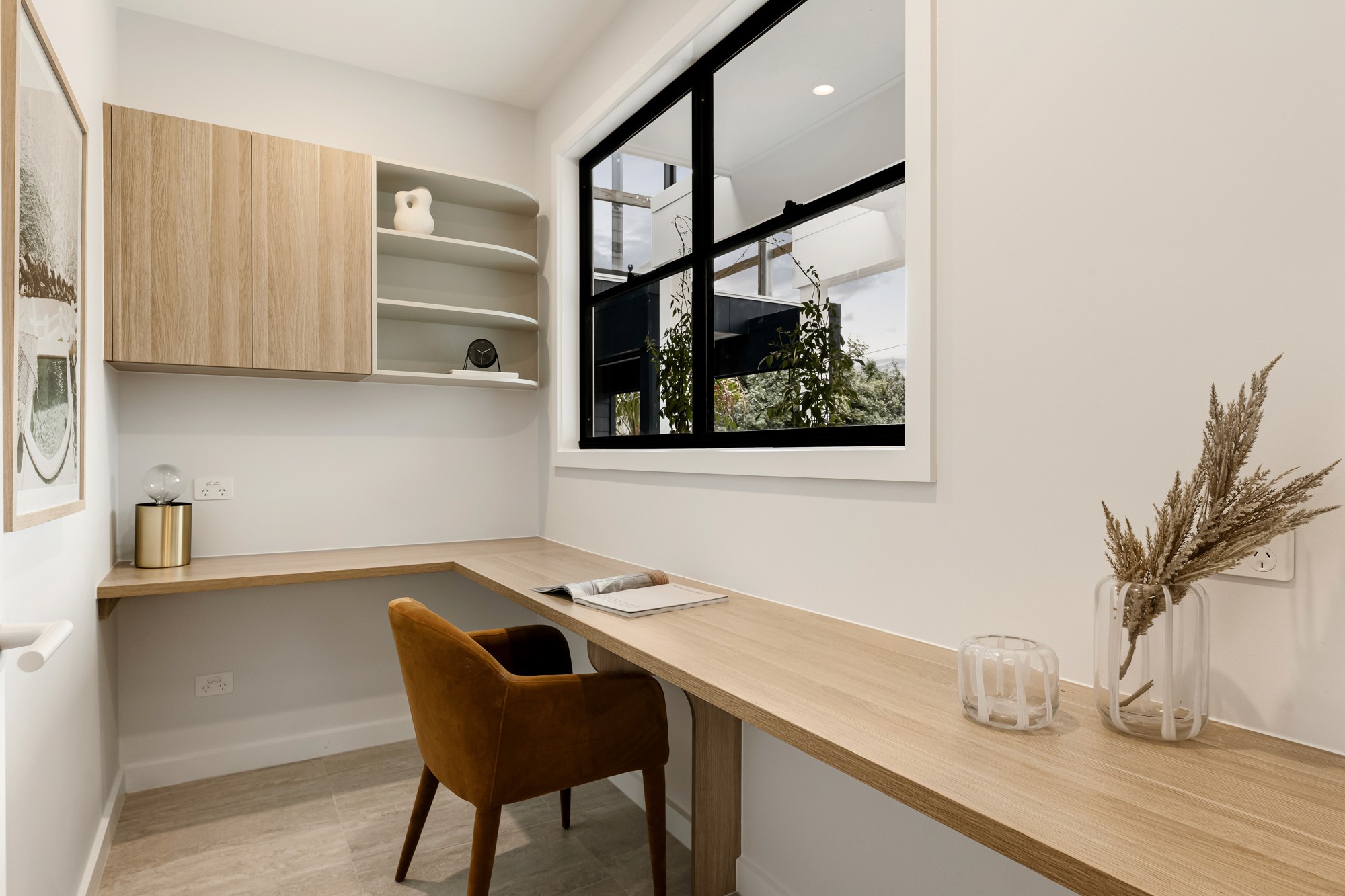 Built-in study nook with a long timber desk, shelving and warm-toned joinery.