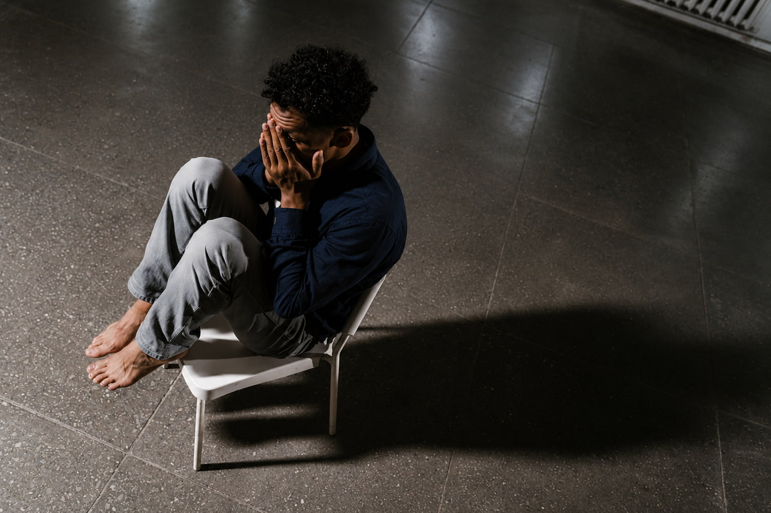 Distressed man sitting alone, symbolising fear and anxiety