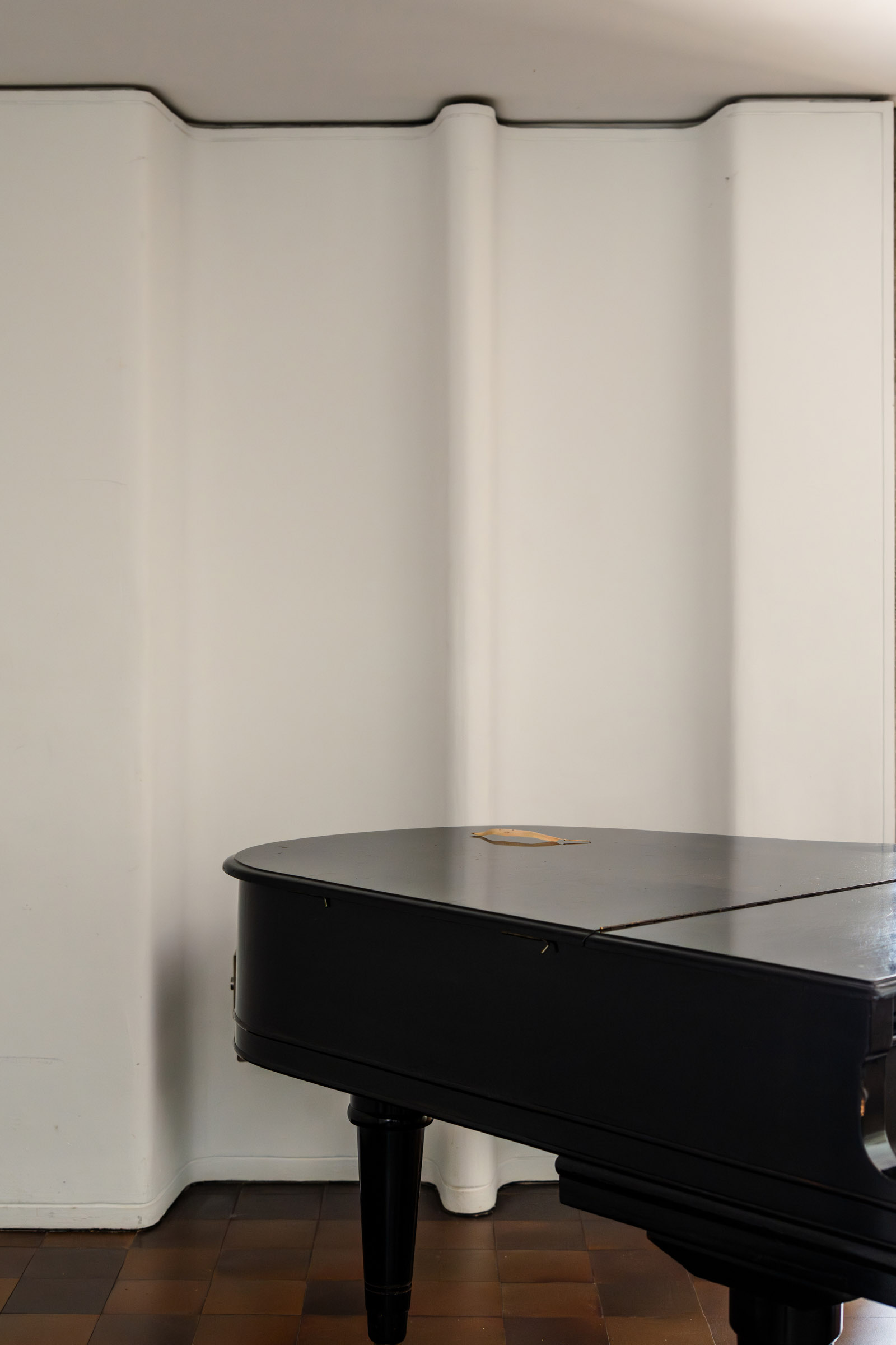 Piano set against the sculptural concrete walls of Casa Carvajal.