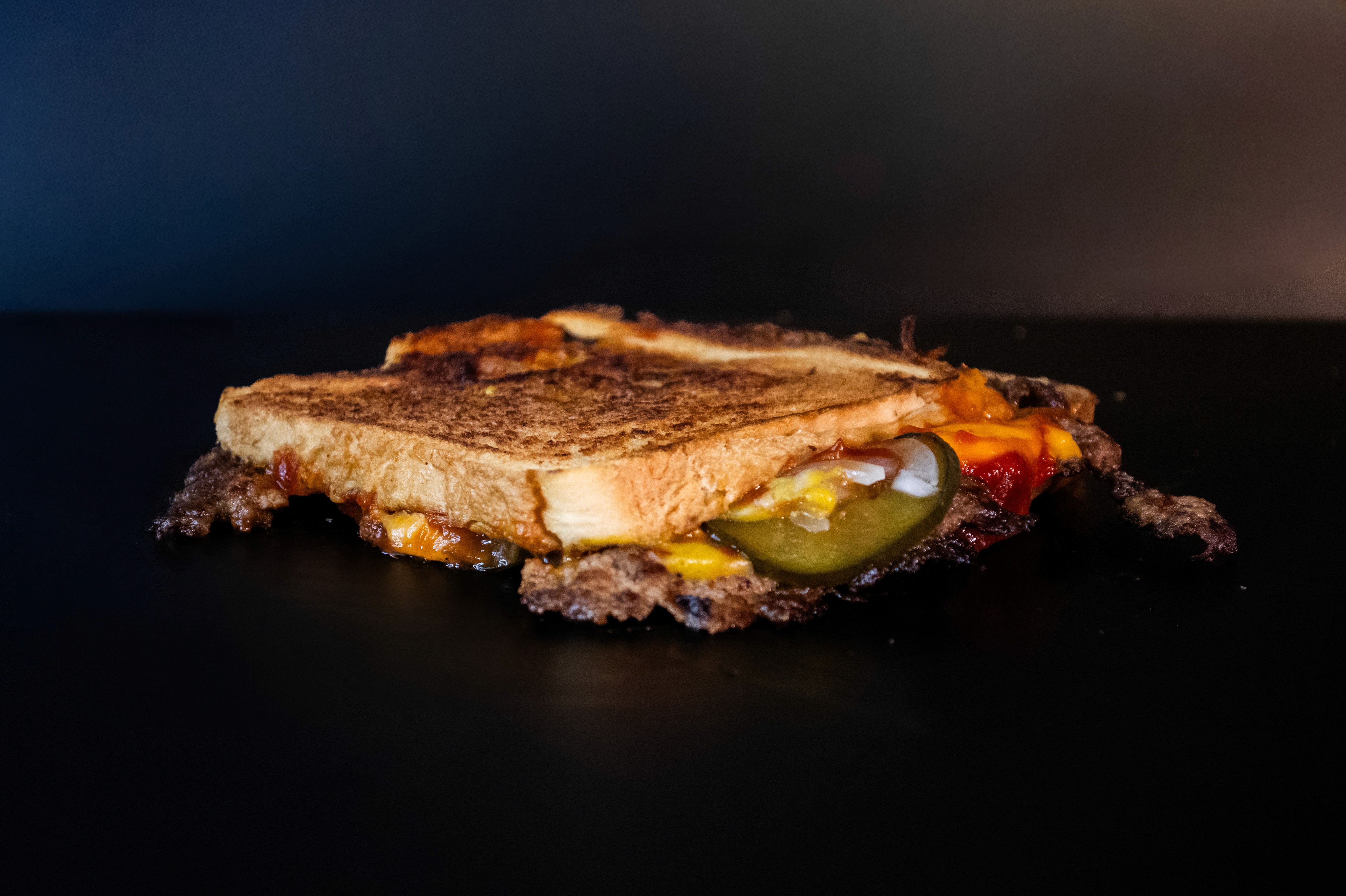 tostado con cebolla, cheddar, mostaza y pepinillos.