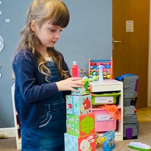 In the Horizon Hub classroom, a child is playing with stacking bricks