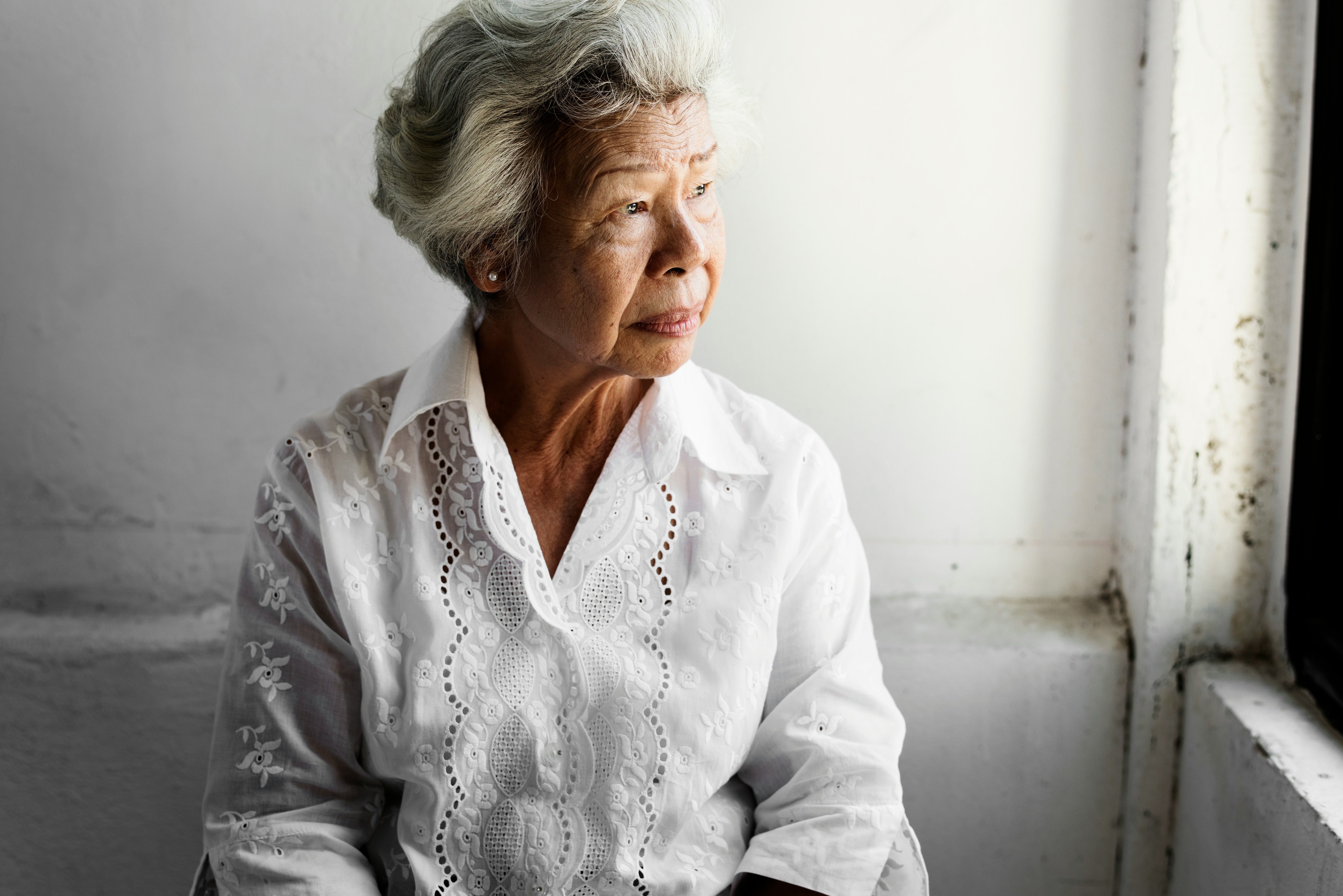 elderly woman looking out a window