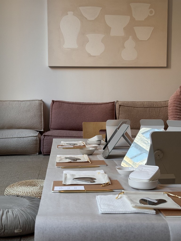 A long table set with gua sha tools and place cards for a workshop at an SYI event