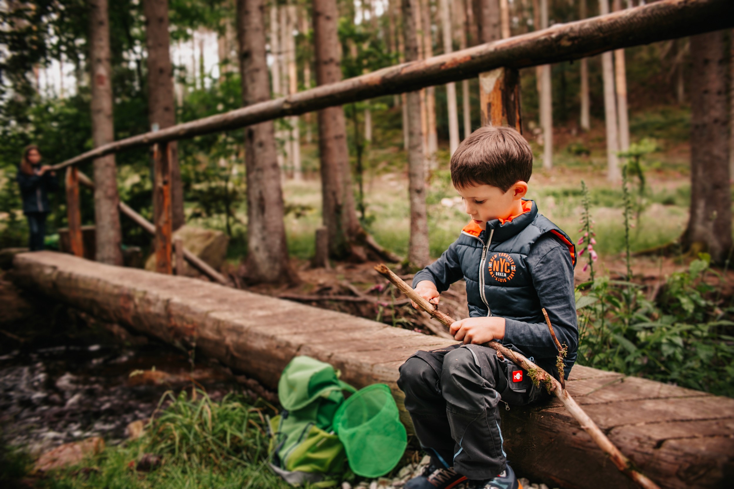 Junge schnitz mit einem Messer aus dem grünen Rucksack