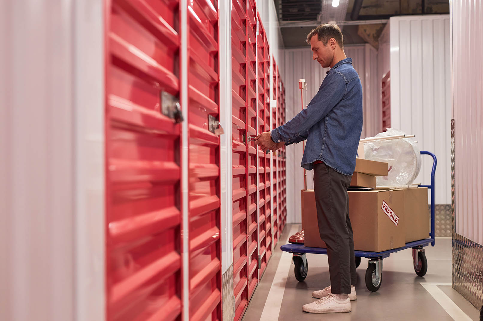 A man carrying a box into a storage unit for storing pet gear by Extra