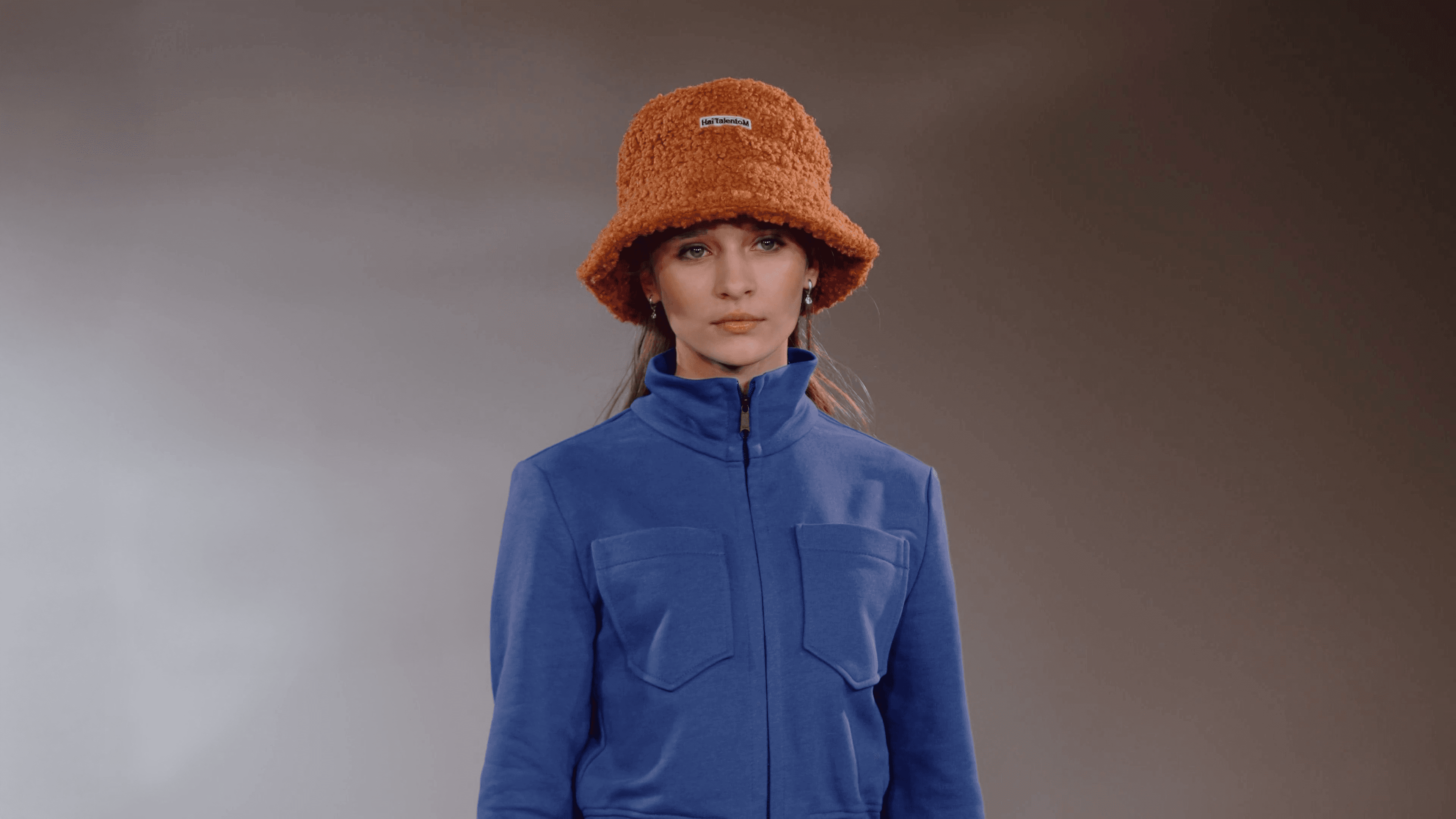 A girl in a red hat at a fashion show