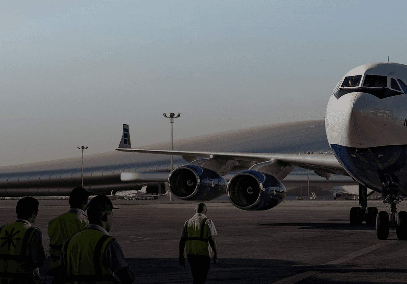 an airplane parked on the tarmac at sunset