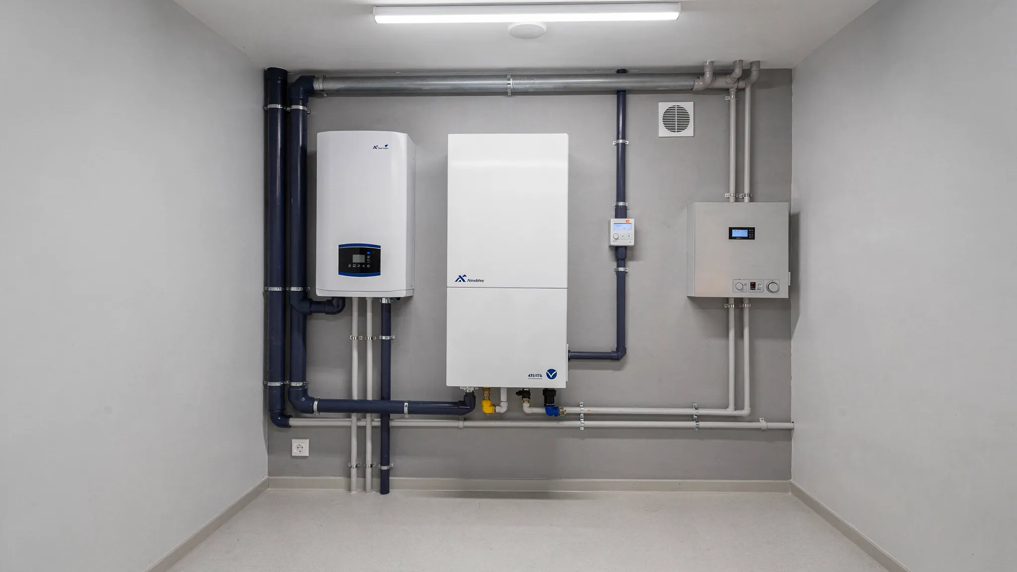 Een overzichtelijke technische ruimte in een moderne energiezuinige woning met warmtepompunit, ventilatiebox en netjes weggewerkte leidingen, zonder zichtbare rommel of complexe bediening.
