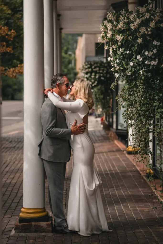 Newlyweds kissing beneath a covered downtown walkway