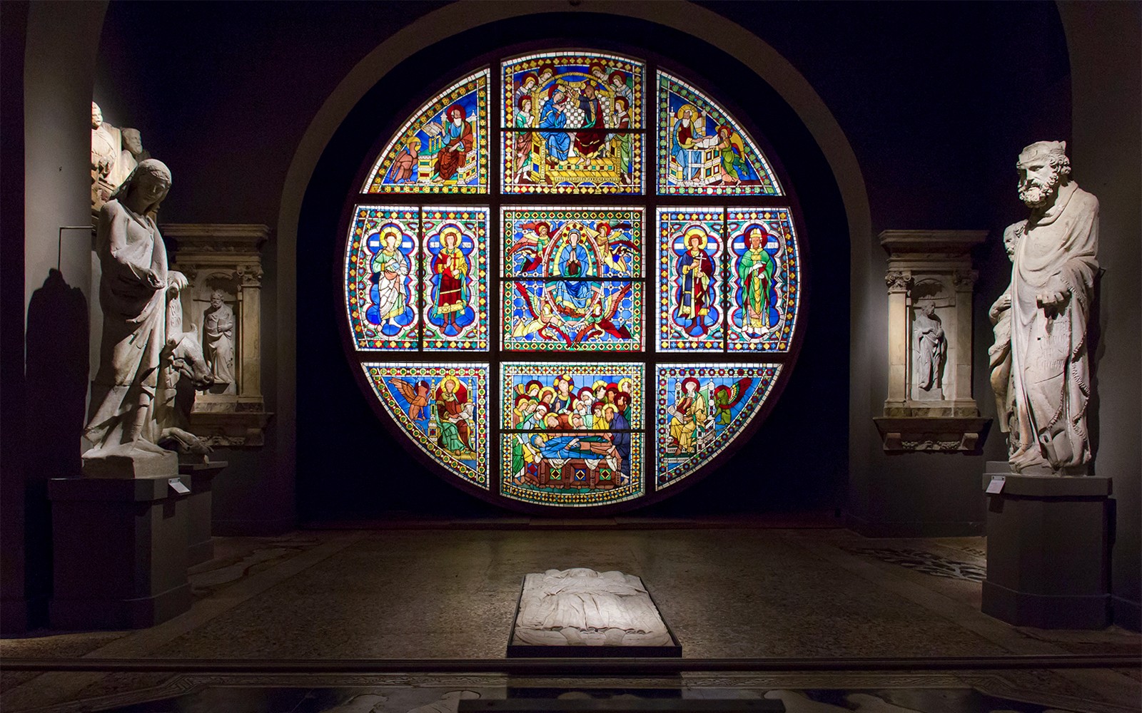 Stained glass window and statues inside Museo dell'Opera Siena