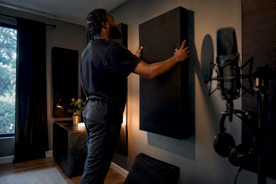 Hands installing acoustic panel in studio
