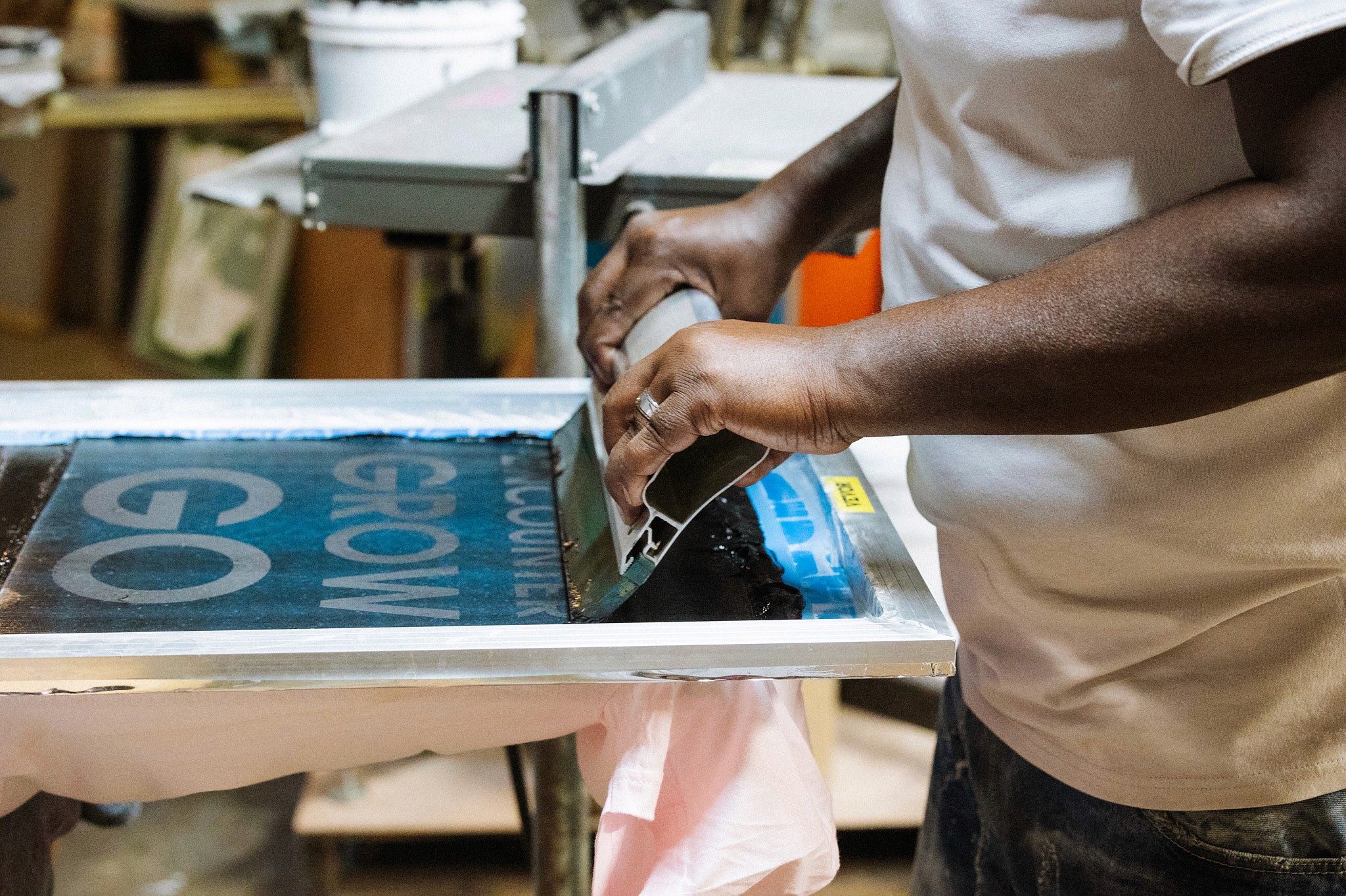 small business owner screen printing in a garage