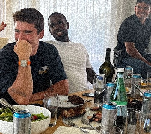 A group of men standing around each other in a room