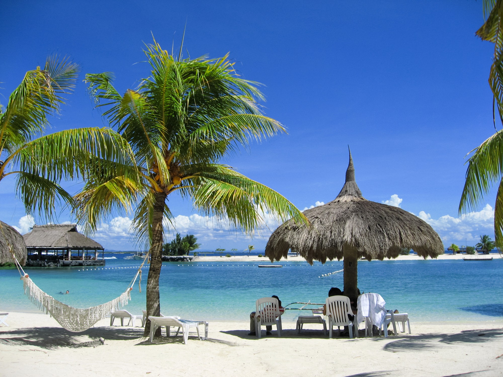 brown wooden beach lounge chair on beach during daytime