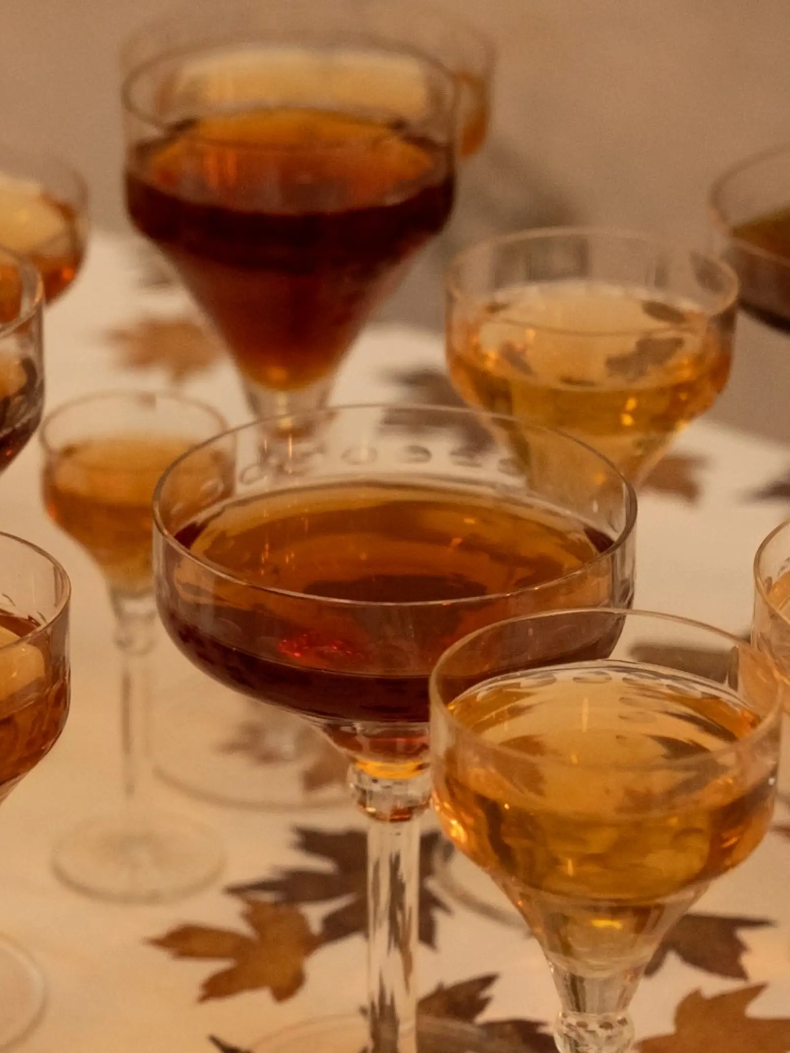 Copas con bebidas ámbar y doradas para propuesta visual de evento otoñal, reflejando sofisticación y calidez.