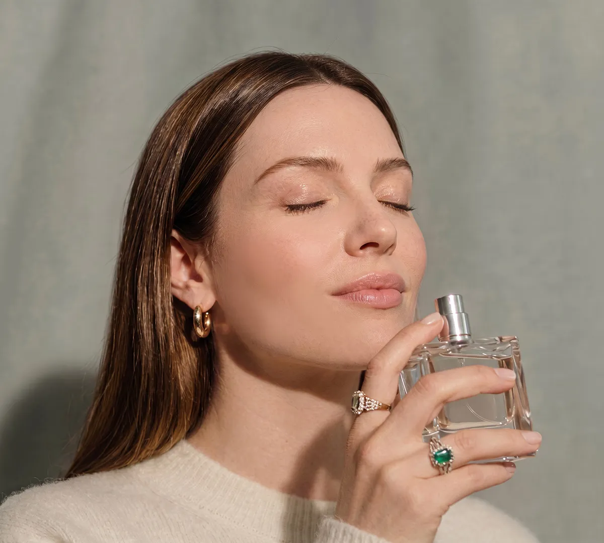 mujer oliendo un frasco de perfume