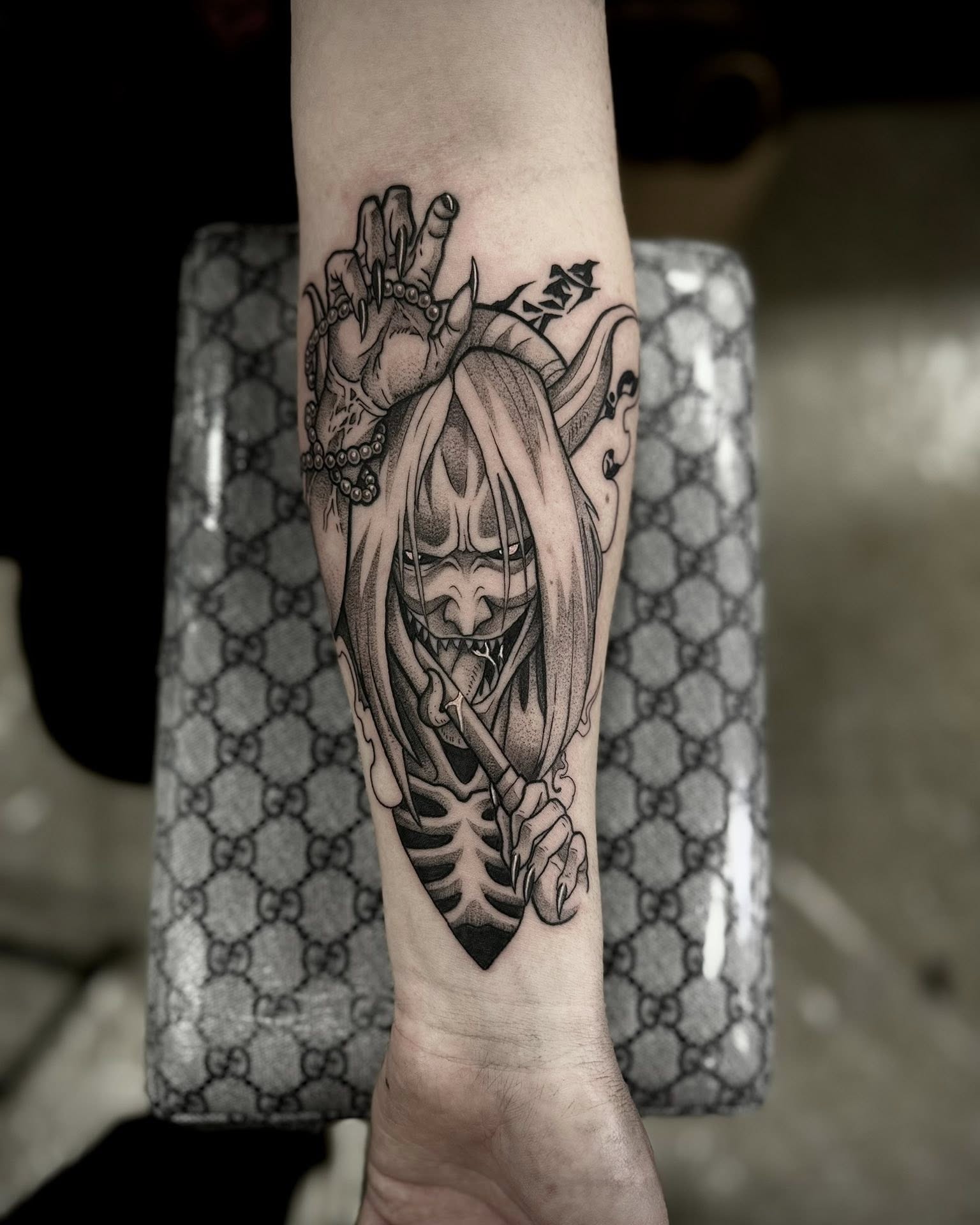 A forearm tattoo of Nezuko Kamado from Demon Slayer, depicted in a stylized anime art style. She is holding a sword.