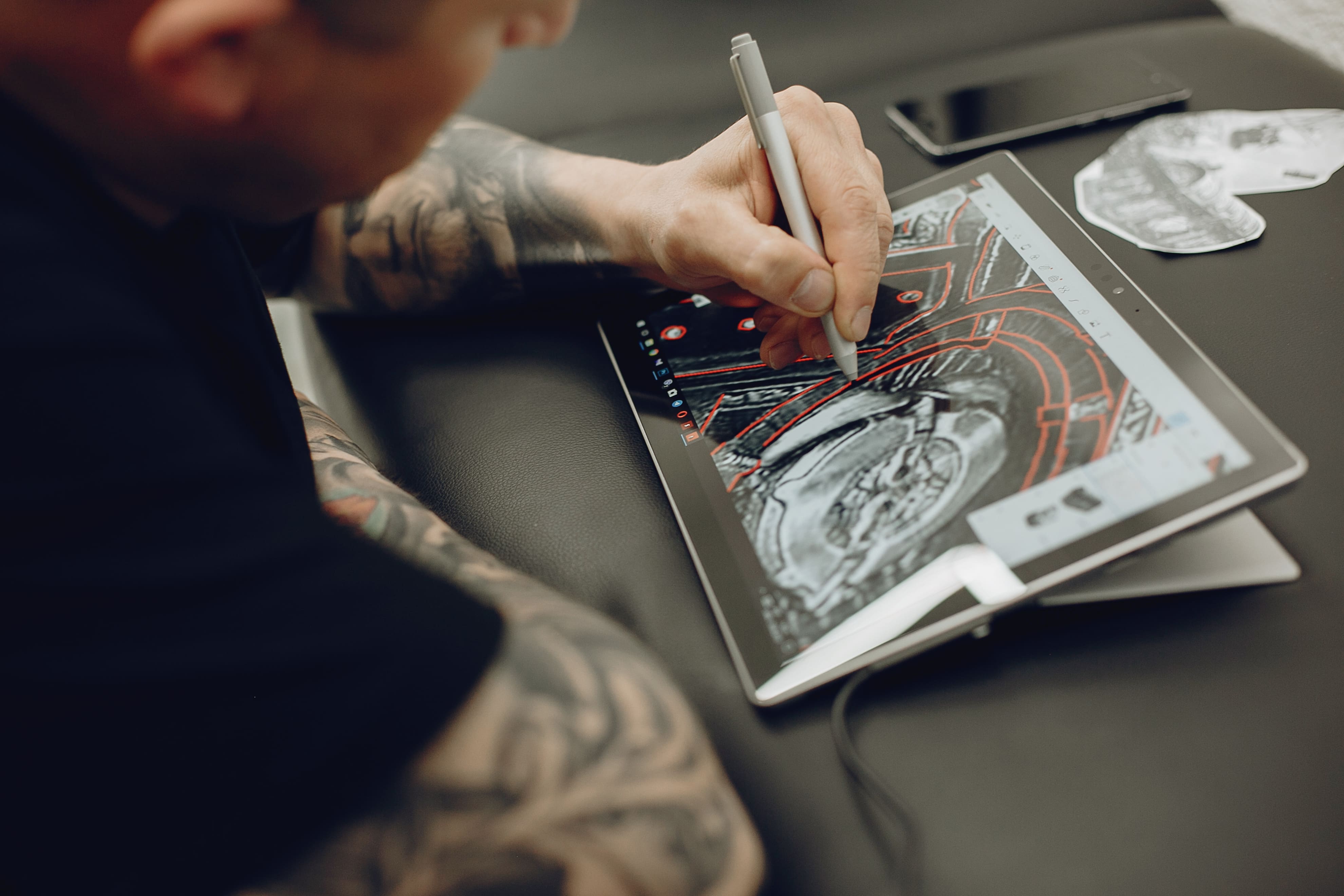 Tattoo artist creates tattoo template with stylus on tablet