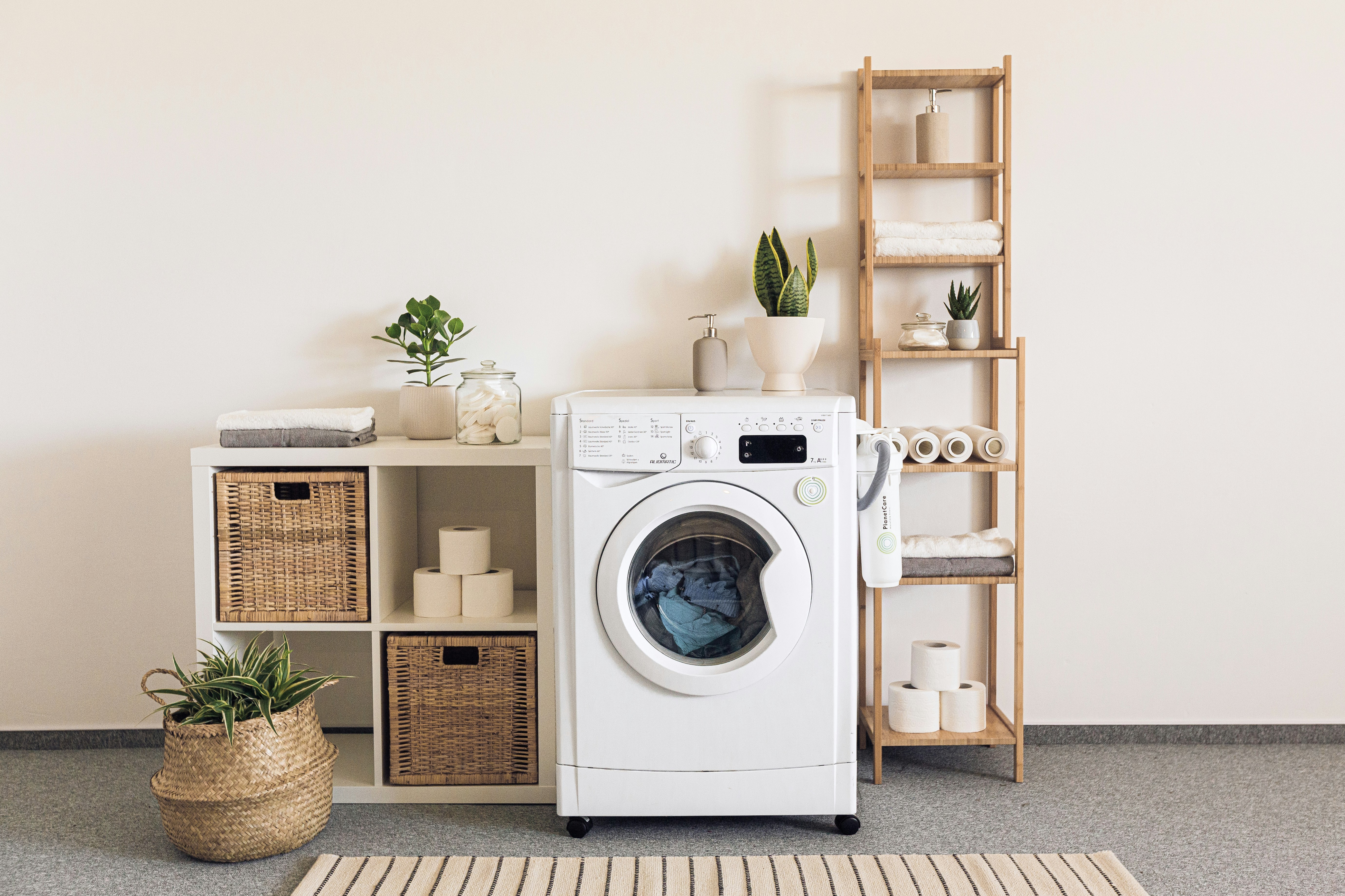 Laundry machine, a mat and a shelf next to it.