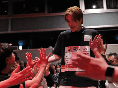 観客とハイタッチをしながら入場する選手