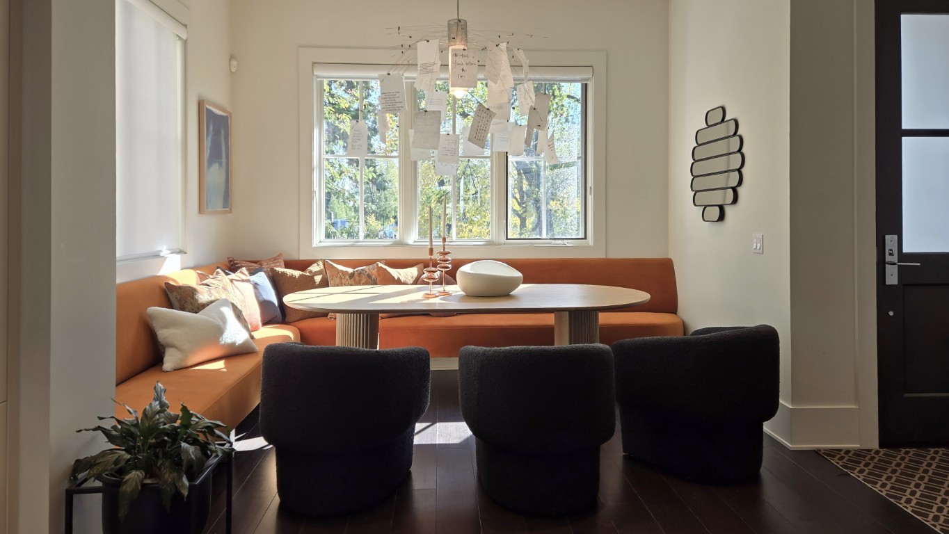 Cozy indoor living room with an orange couch and dark, round table seating.