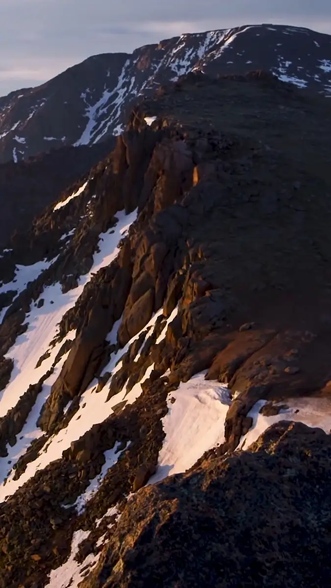 Bird's-eye view of a Pikes Peak blanketed in snow, revealing its dramatic contours and icy expanse.