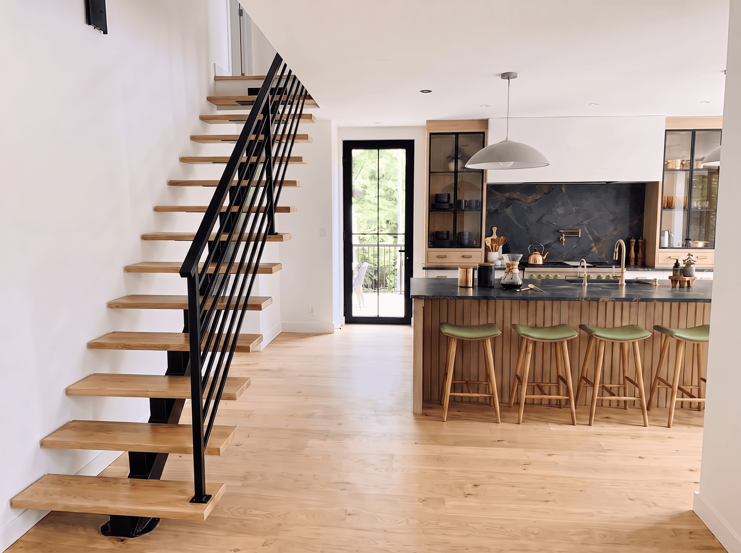 Black central stringer staircase with white oak treads in a bright living space