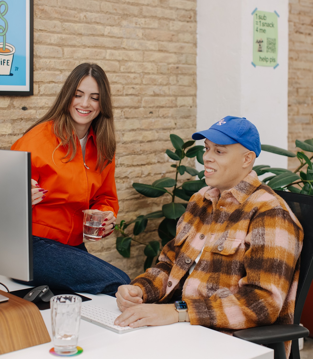 Two designers working together, discussing a design behind a desk