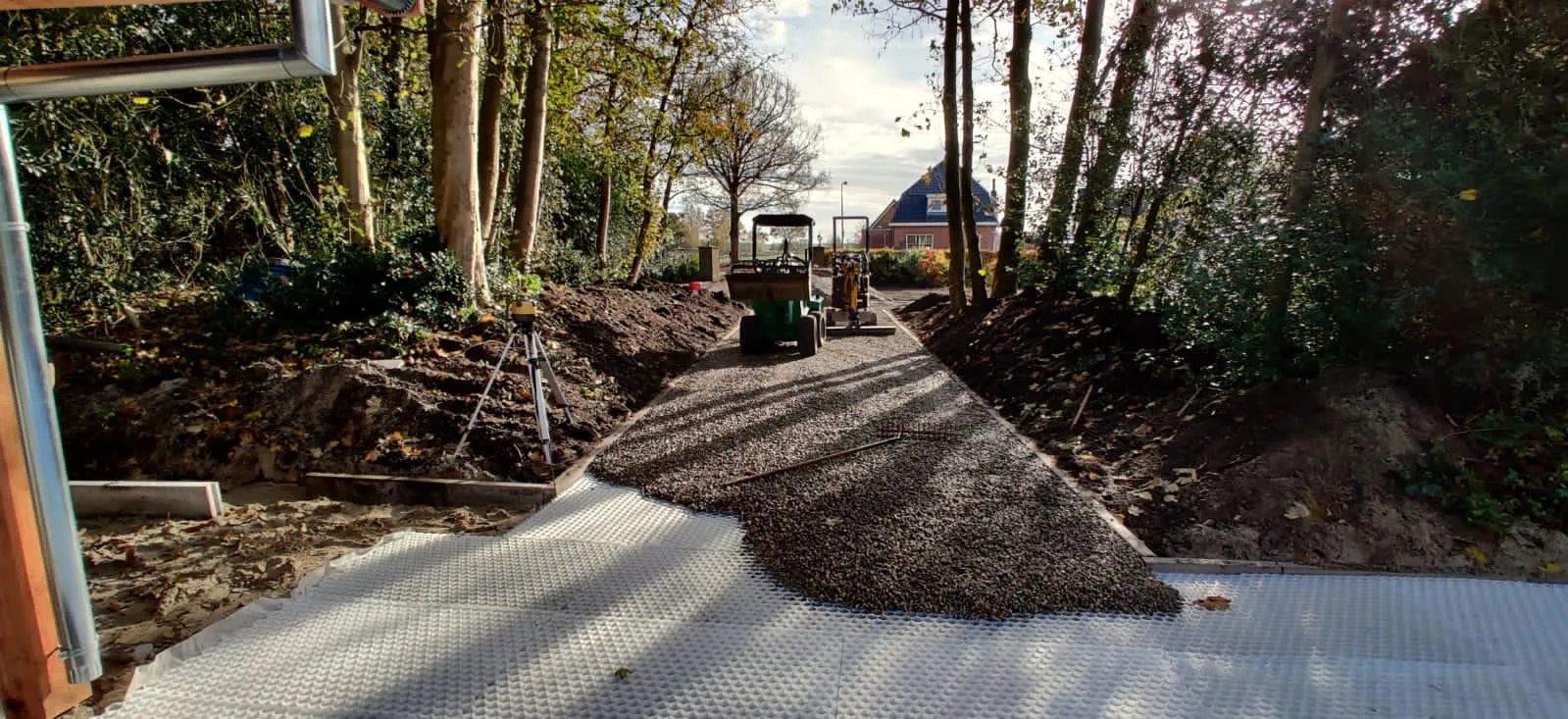 Tuinaanleg tussen bomen met minigraver, worteldoek en halfverharding voor stabiele paden in tuin in Gorredijk
