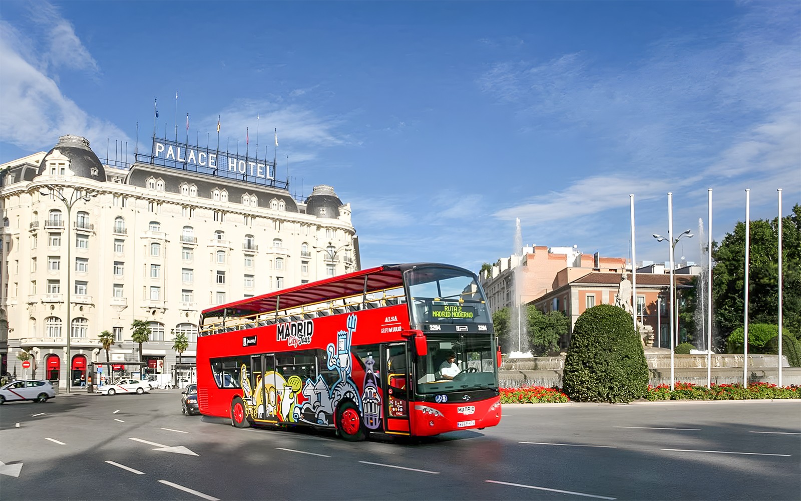 Autobus Hop-On Hop-Off vicino al Palazzo Reale nel paesaggio urbano di Madrid.