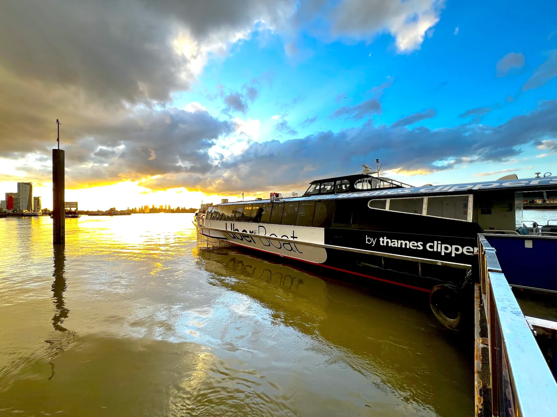 Upriver view of the Thames on a Spring evening with the Uber boat docked at Woolwich Arsenal pier just a few minutes walk from creative Kin's London podcast studio at Woolwich Works.
