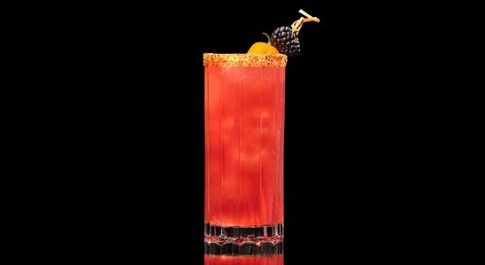 A closeup of a Blackberry Bridge drink against a dark background.