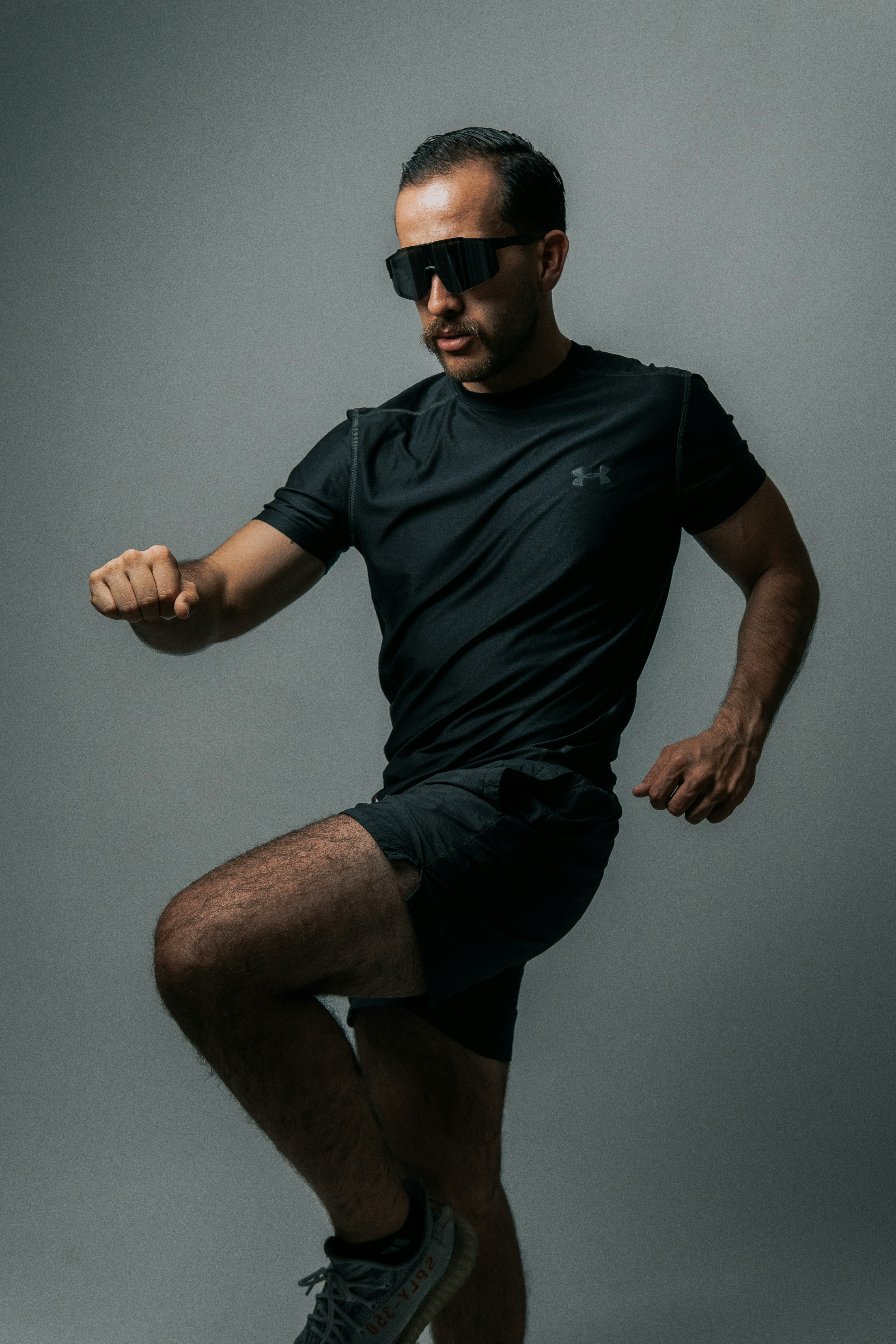 Runner in black athletic wear strikes a pose.