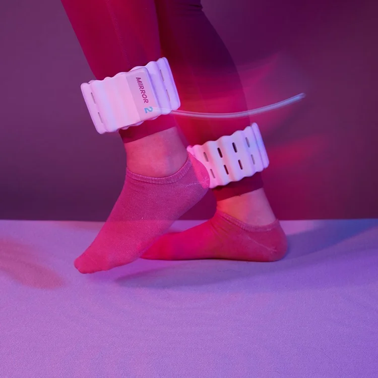 Person wearing Mirror connected ankle weights while stepping in purple lighting