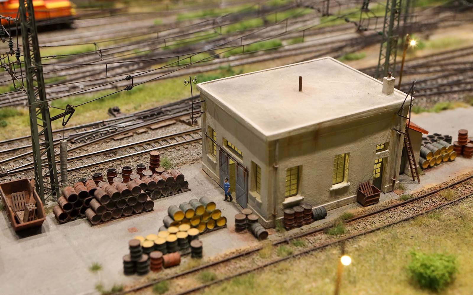 Scena ferroviaria in miniatura con un edificio e barili presso il Museo del Treno in Miniatura Hzero.