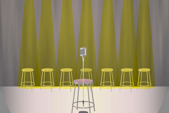 A silver microphone stands on a gray stand in front of a row of yellow stools. The backdrop consists of five vertical panels of olive-green fabric draped over a gray curtain. The floor is white.