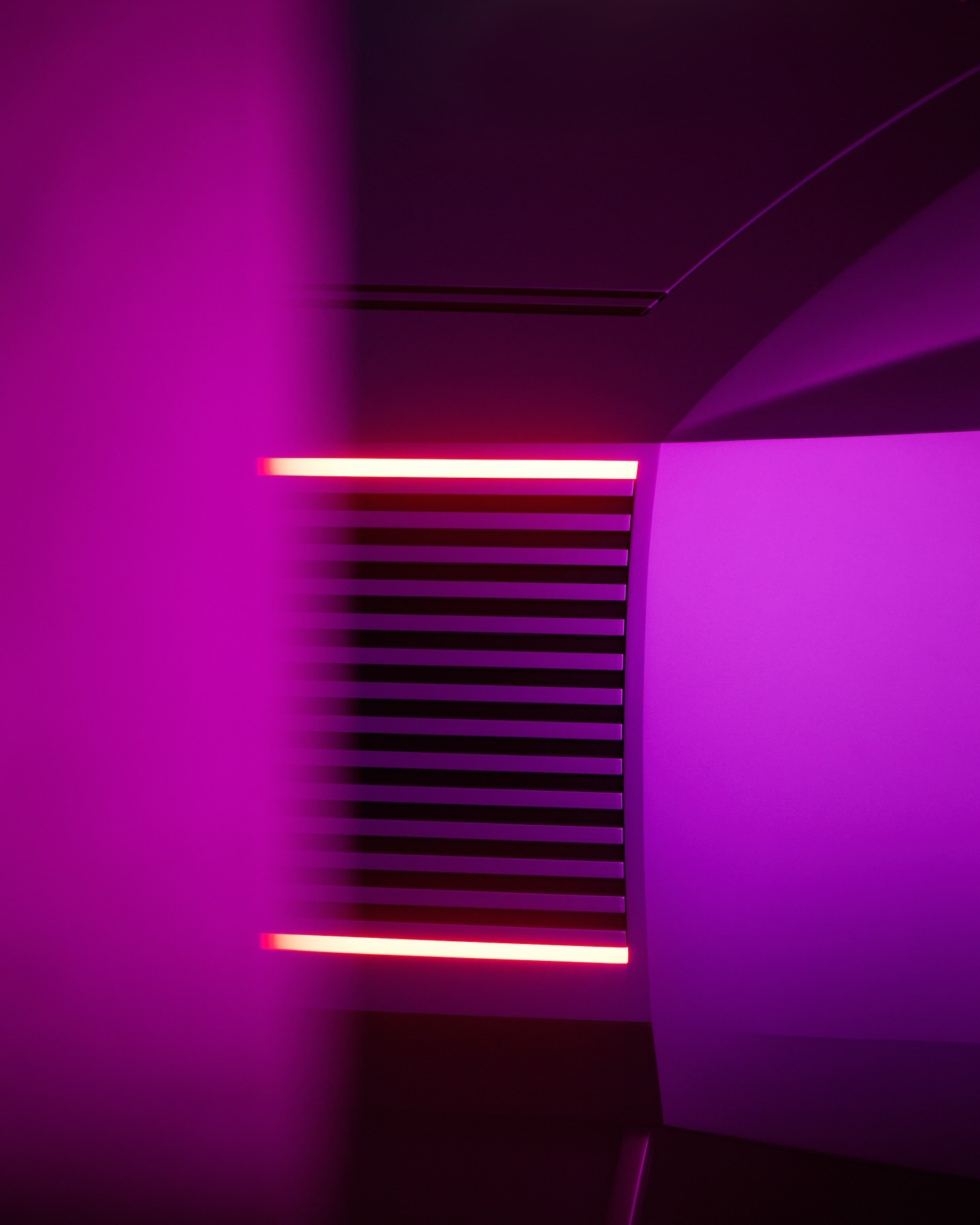 Close-up of a yellow tennis ball sitting on a green court, positioned near the white center line.