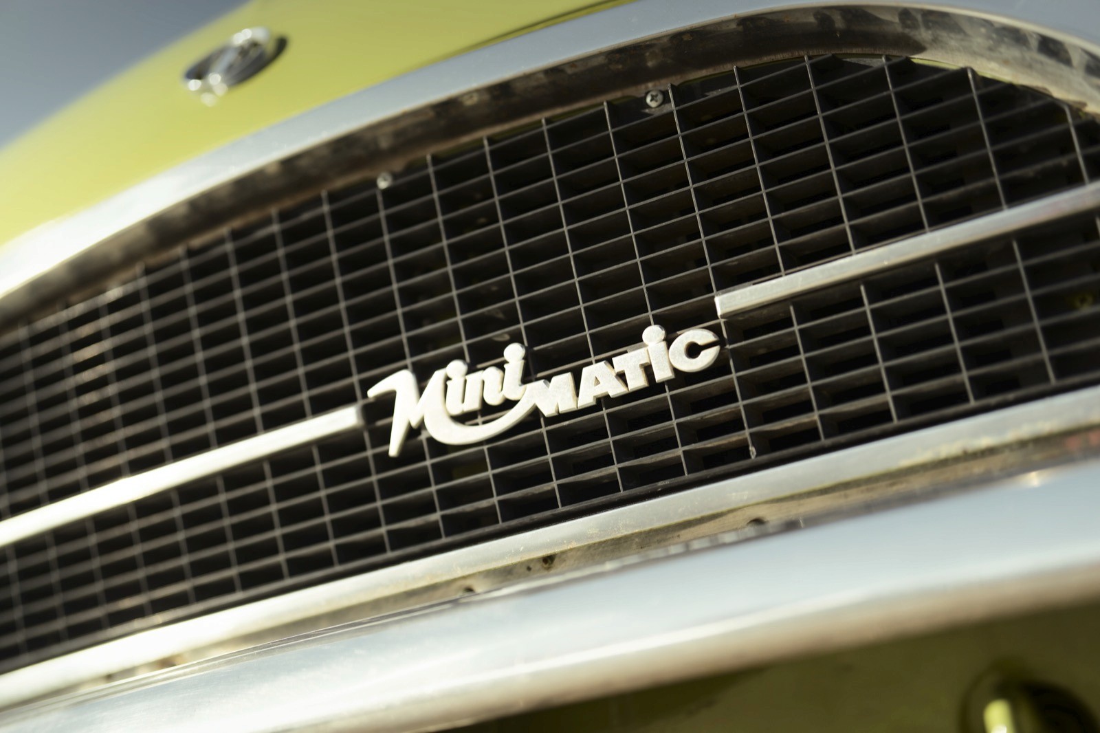Close-up of a vintage car grill with the name "Meteor" prominently displayed in script style.