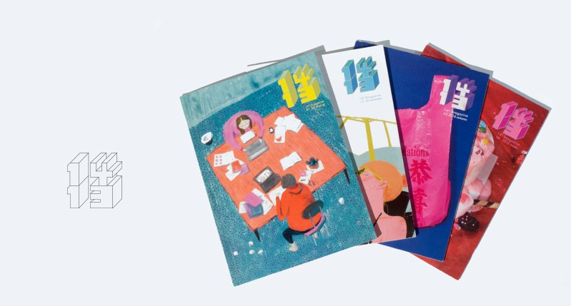 A set of four colored art magazines. On the first one there is a drawing of two people sitting at a table and working on laptops. Alongside the magazines there is a 3d Asian letter.