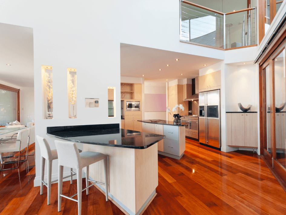 Modern white kitchen with timber floors freshly painted by AUPaint in Hope Island. Sleek finishes, natural lighting, and a vibrant new feel.