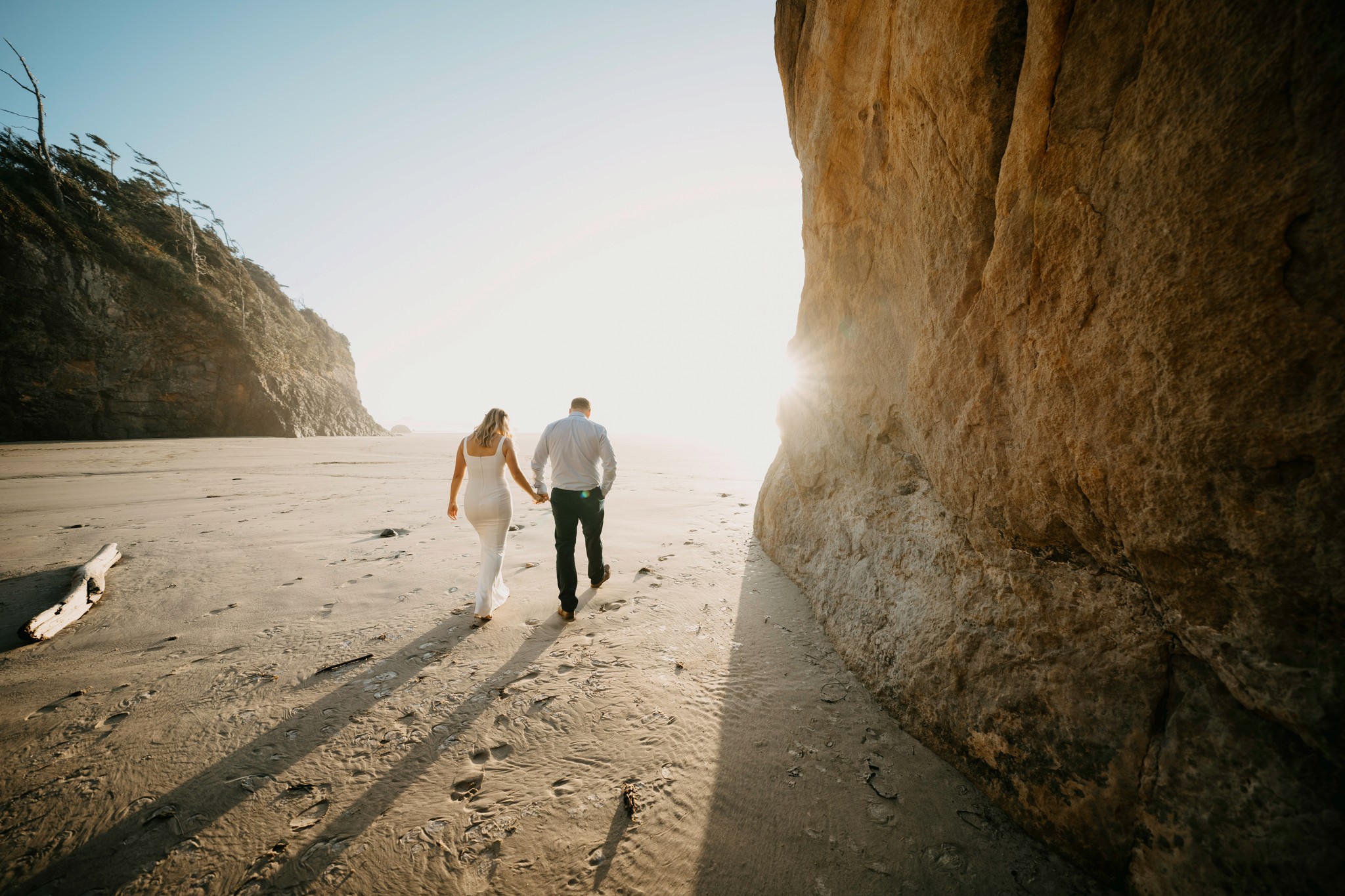 Couple holding hands walking down the beach