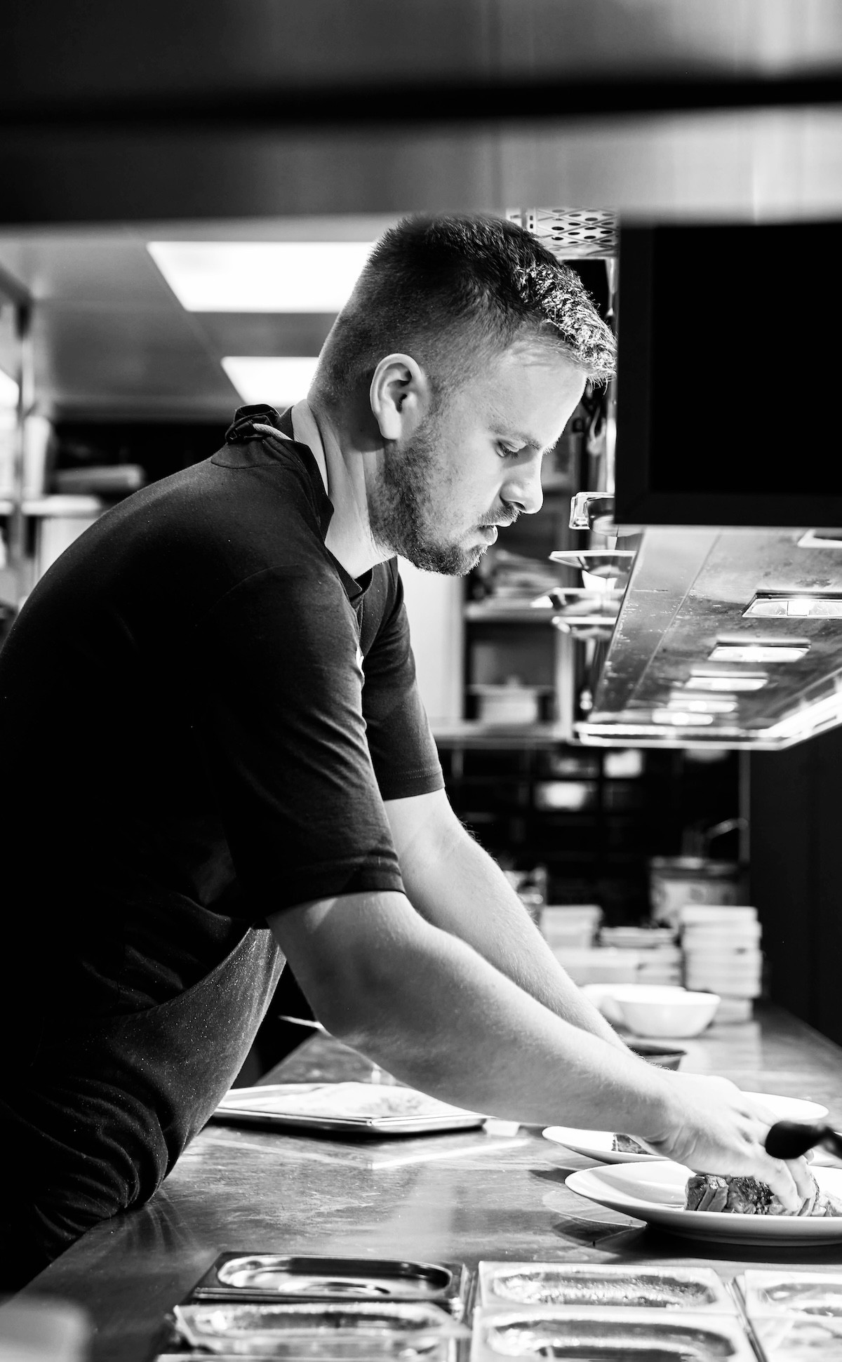 Focused chef perfecting a dish in the kitchen of La Fontanella