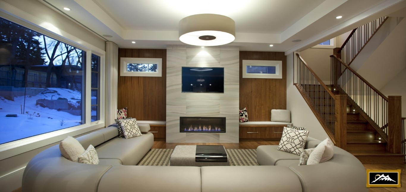 Image of Luxury living room with gas fireplace, built-in seating and large windows by KHD Homes interior design.