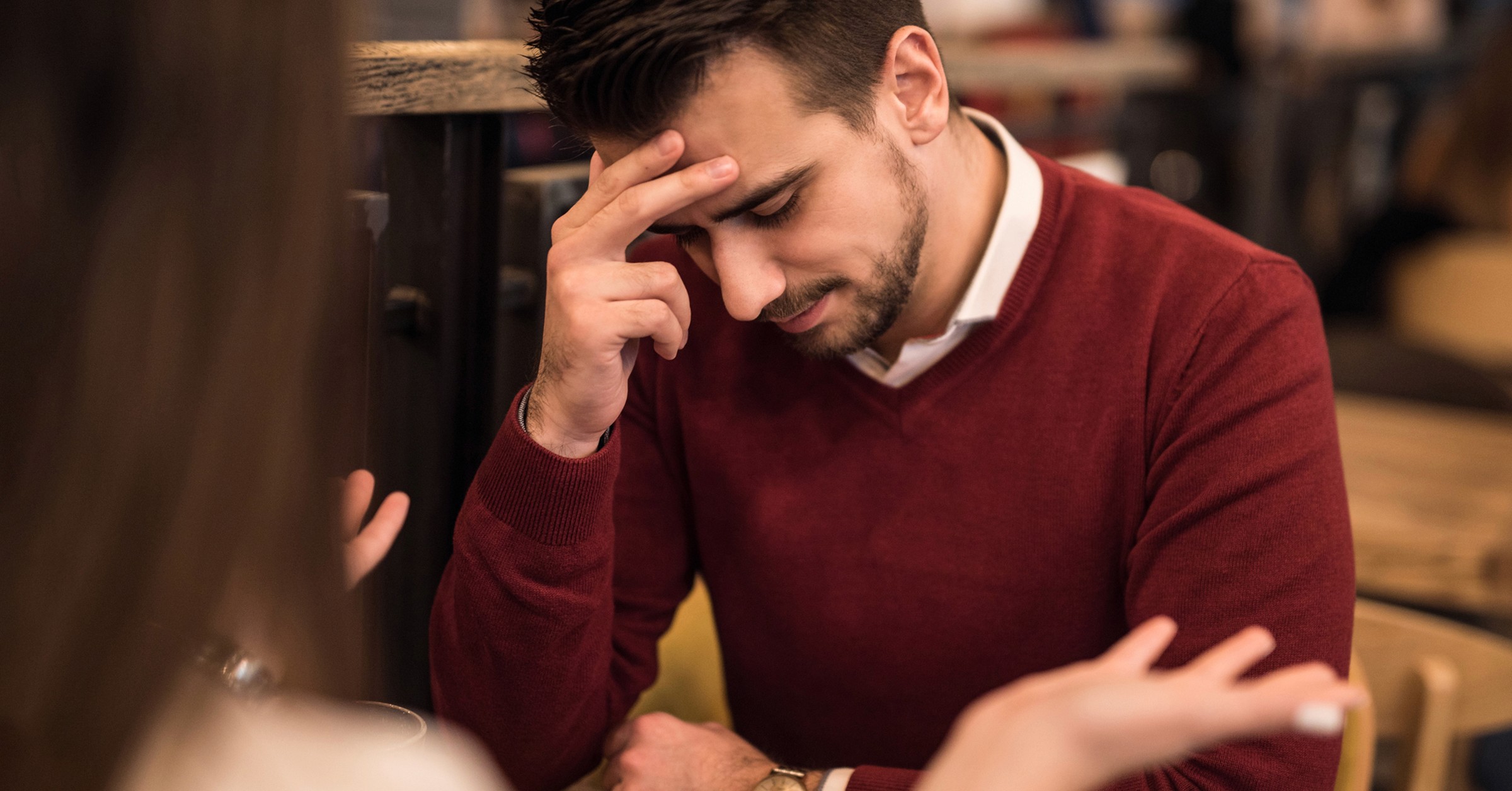 En kvinne sitter og klager mens mannen holder hånden på hodet og ser ned.